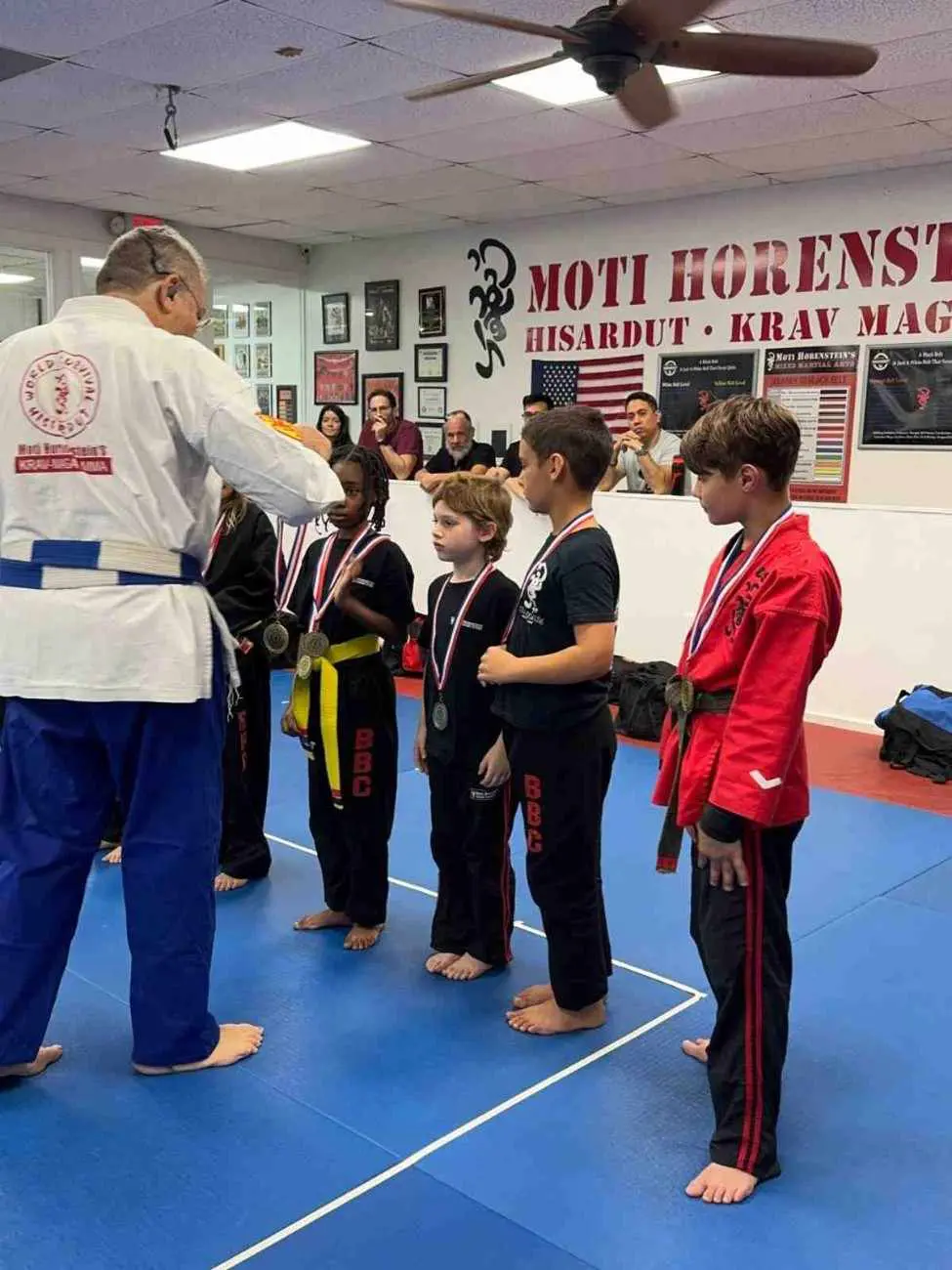 Children receiving medals after participating in jiu jitsu competition or belt evaluation