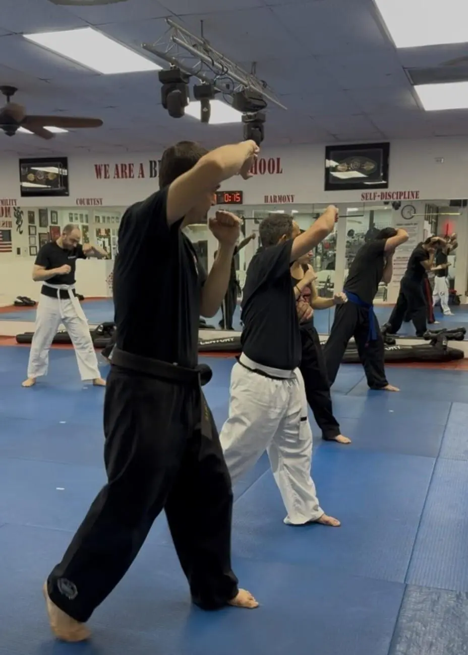 Adult students practicing jiu jitsu striking and defensive movements during group class