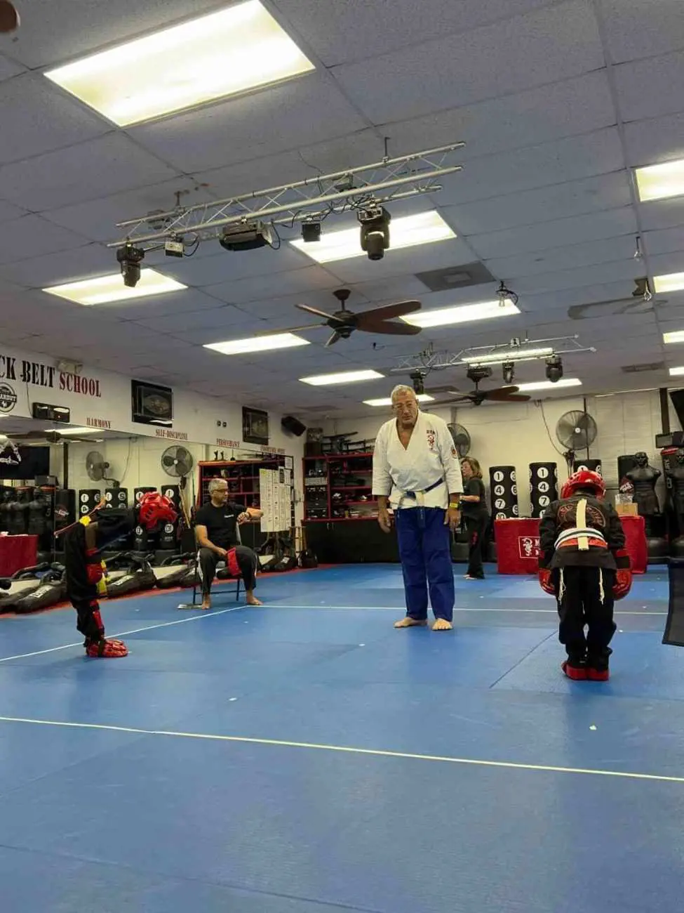 Jiu jitsu instructor guiding youth students during sparring practice inside martial arts academy