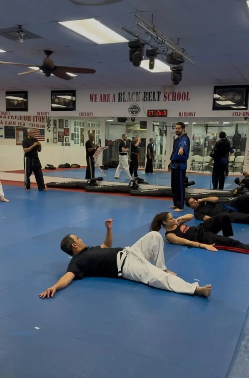 Brazilian jiu jitsu class with students practicing grappling techniques in dojo