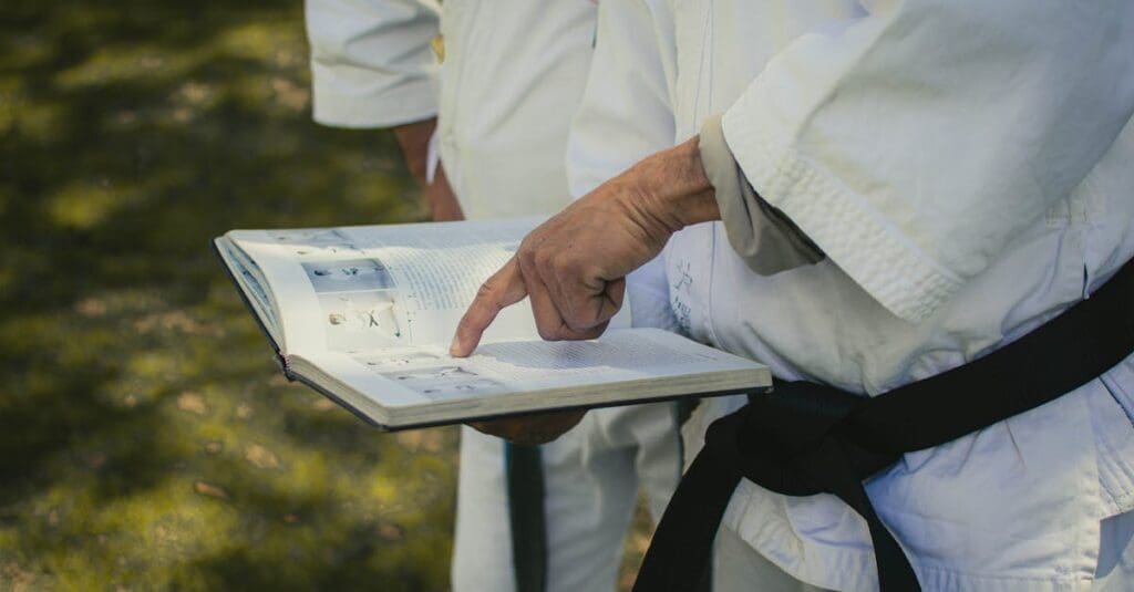 Instructor reviewing a martial arts book, showing types of martial arts
