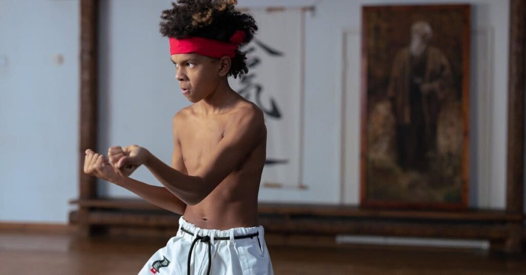 Young student practicing hand positioning in class, showing martial arts basics