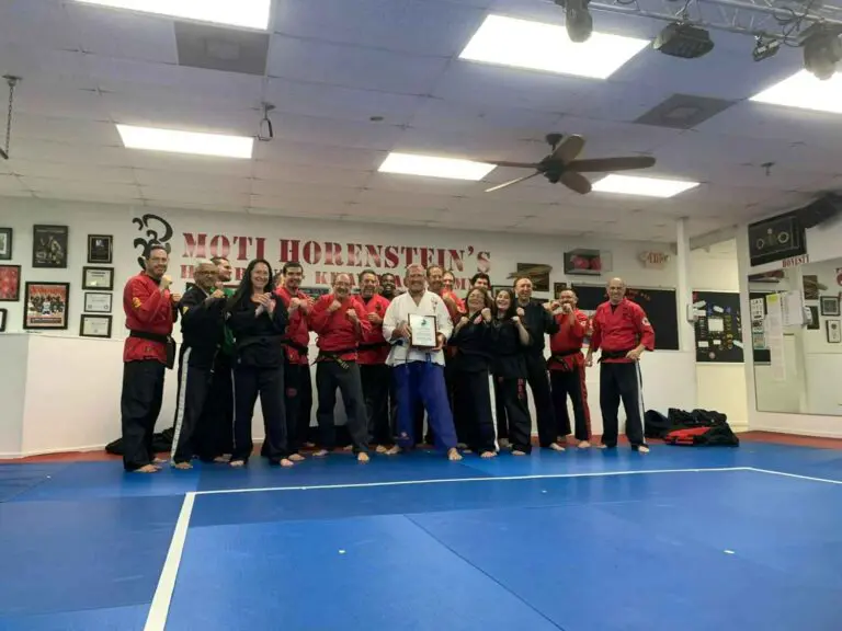 Martial arts class posing together with a certificate after a belt promotion jiu jitsu transitions for beginners